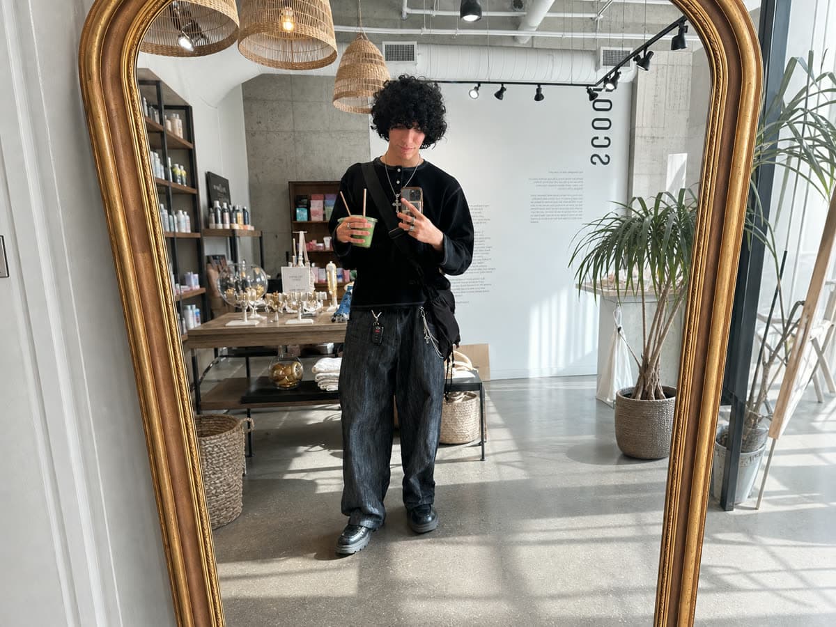 A layered black outfit in a mirror — the kind of photo Outfittr starts from