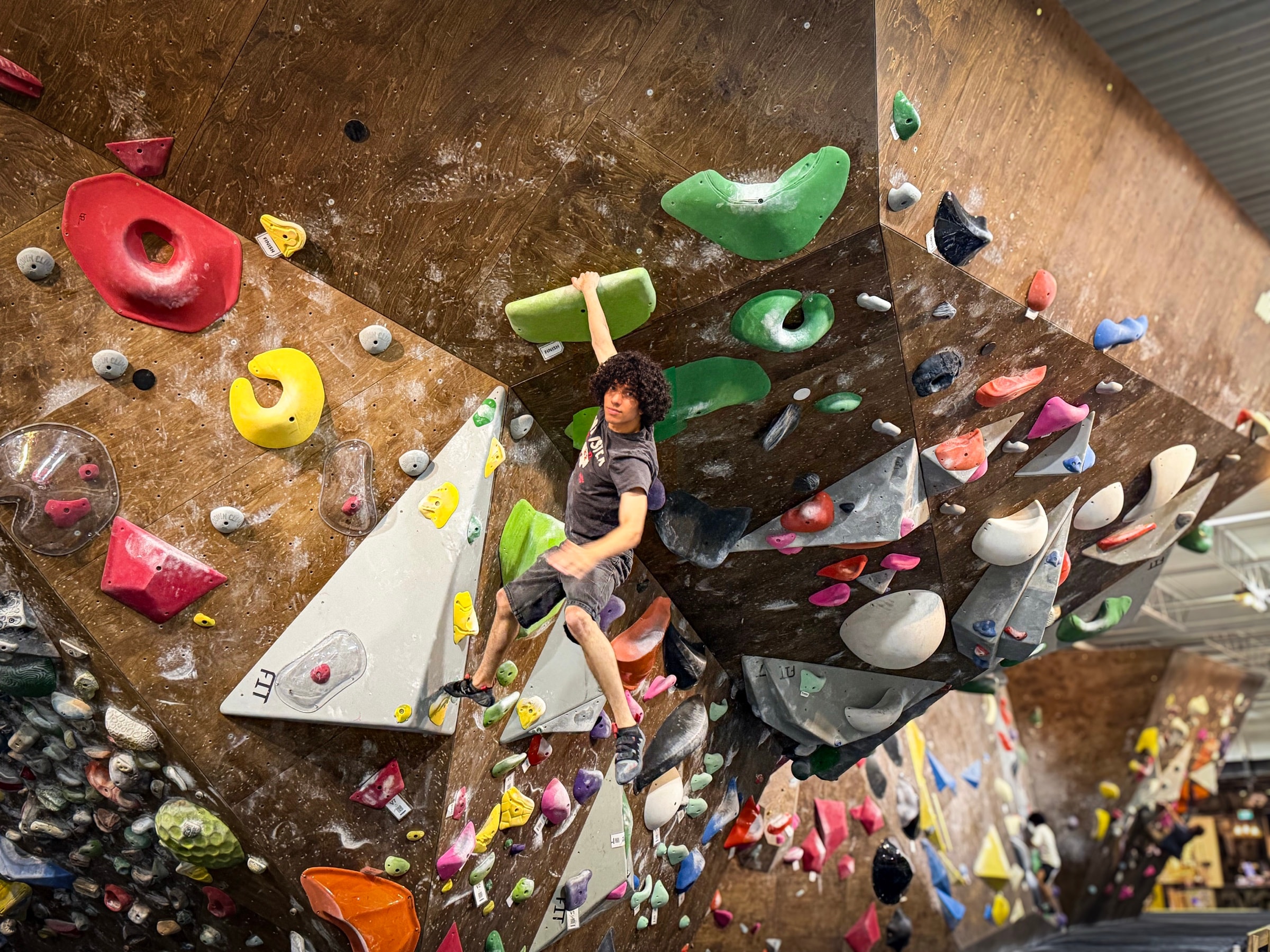 Pierre bouldering on an indoor climbing wall