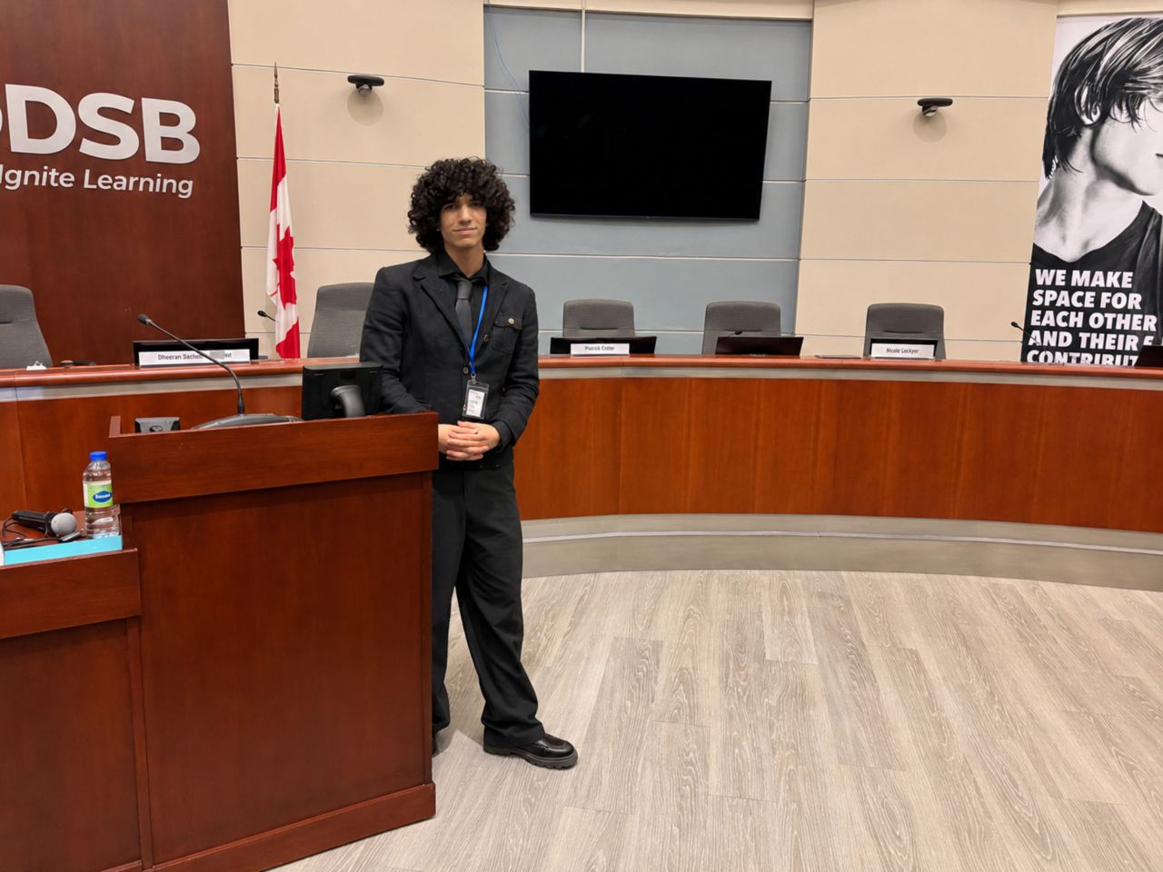 Pierre in a suit beside the lectern at DRMUN