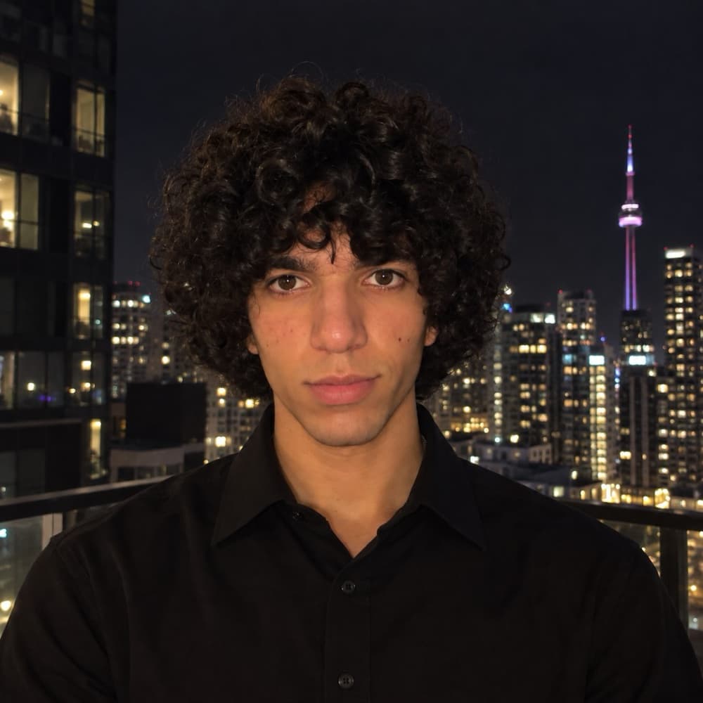 Pierre at night on a Toronto balcony, CN Tower lit behind him